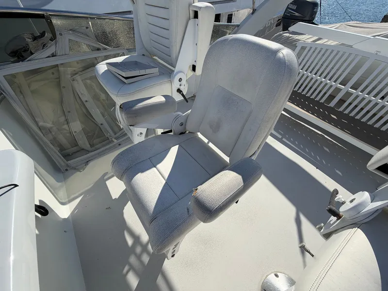 Slide: The Image of A white captain's chair on a boat deck, surrounded by additional seating and a table. - 48