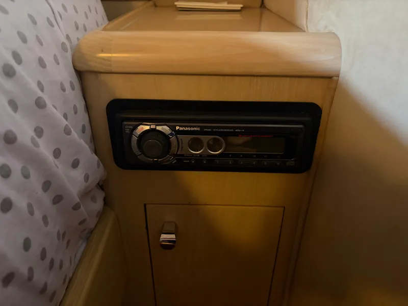 Slide: The Image of A built-in Panasonic radio in a wooden cabinet next to a polka dot pillow. - 26