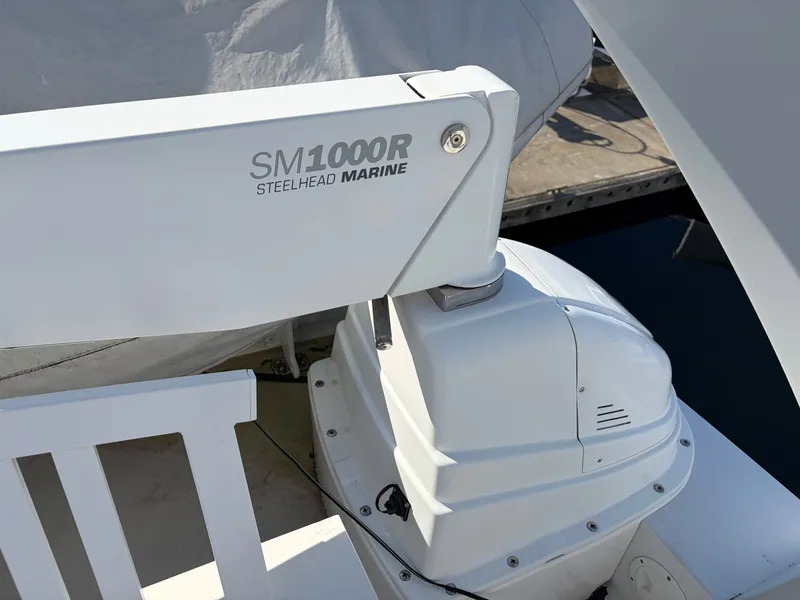 Slide: The Image of A white Steelhead Marine crane, model SM1000R, installed on a boat. - 49