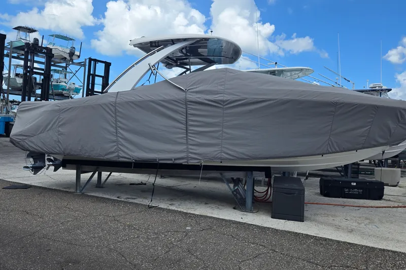 Slide: The Image of 2023 Cobalt 30SC Outboard boat covered, stored on a dock under a blue sky. - 27