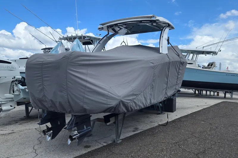Slide: The Image of 2023 Cobalt 30SC Outboard boat covered, parked on a marina with other boats. - 29
