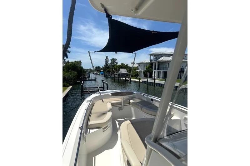 Slide: The Image of 2022 Boston Whaler 270 Dauntless boat docked near waterfront homes under a sunny sky. - 29