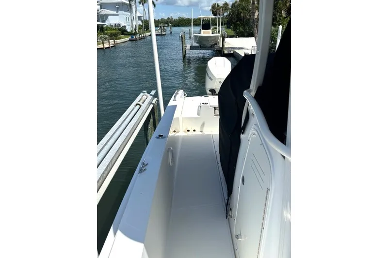 Slide: The Image of 2022 Boston Whaler 270 Dauntless boat docked by waterfront homes. - 23