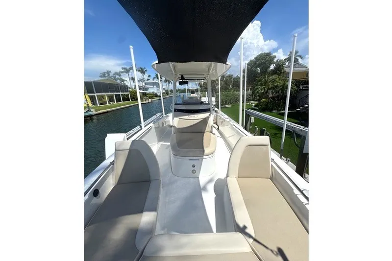 Slide: The Image of 2022 Boston Whaler 270 Dauntless boat interior with seating and canopy on a sunny day. - 27