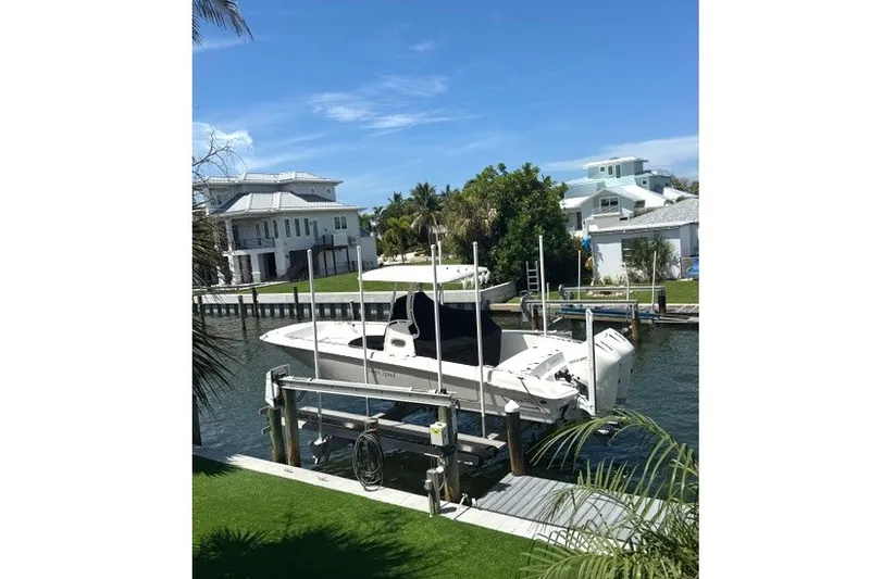 Slide: The Image of 2022 Boston Whaler 270 Dauntless boat docked by waterfront homes. - 25