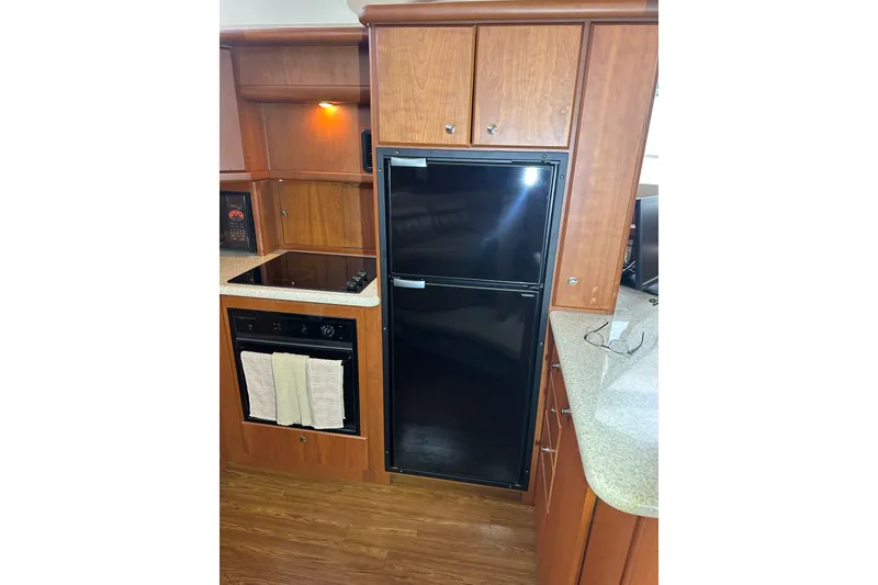 Slide: The Image of 2005 Silverton 43 Motor Yacht kitchen with wood cabinetry and modern appliances. - 23