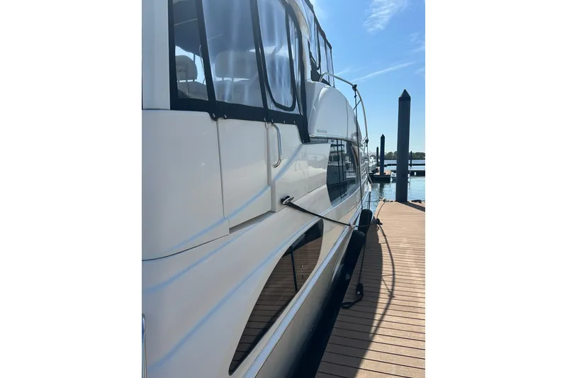 Slide: The Image of 2005 Silverton 43 Motor Yacht docked, showcasing sleek design and spacious cabin. - 13