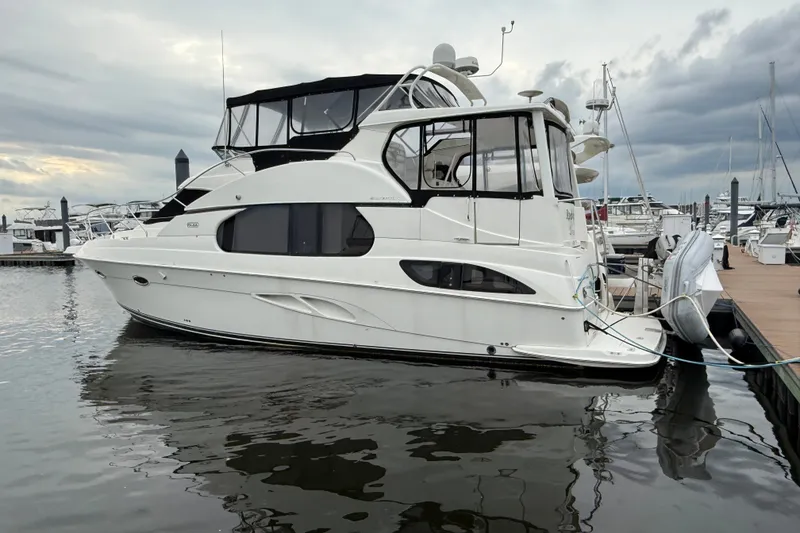 Slide: The Image of 2005 Silverton 43 Motor Yacht docked at marina under cloudy skies. - 1