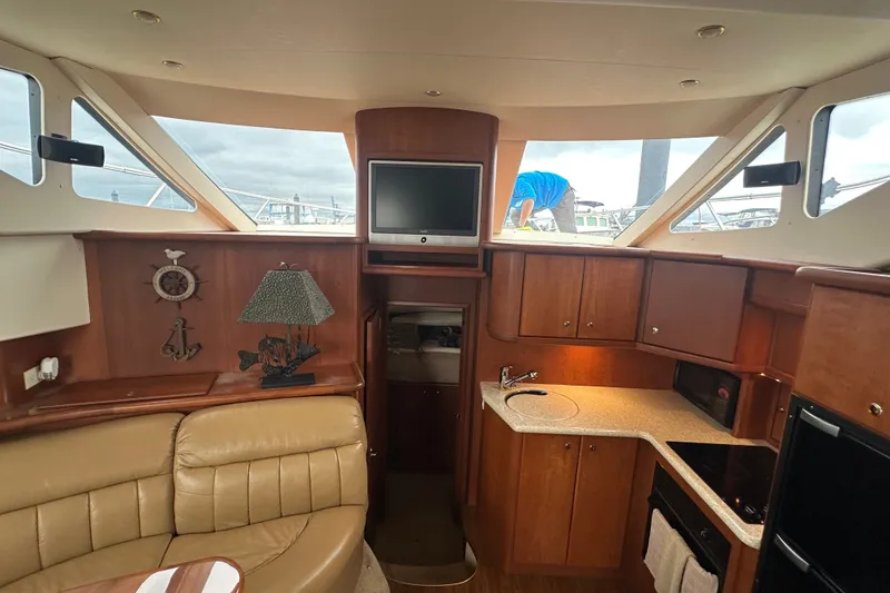 Slide: The Image of Interior of 2005 Silverton 43 Motor Yacht with leather seating, kitchenette, and TV. - 21