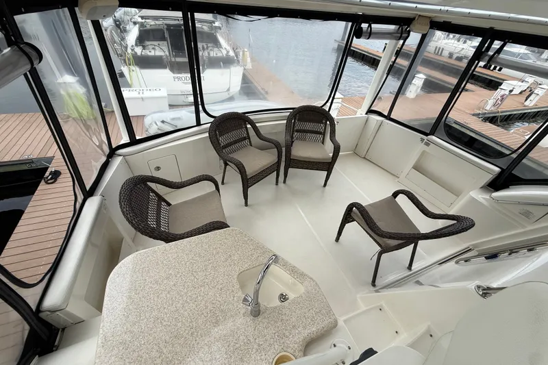 Slide: The Image of Interior of 2005 Silverton 43 Motor Yacht with wicker chairs and a small sink. - 26