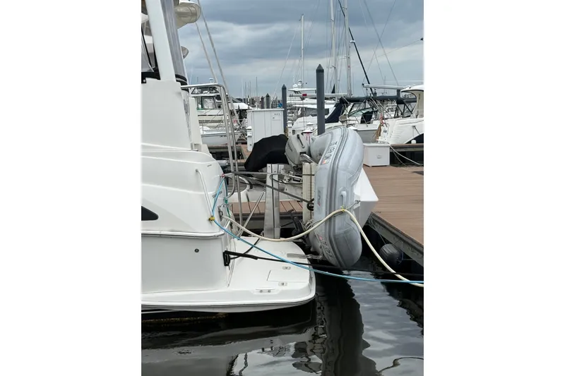 Slide: The Image of 2005 Silverton 43 Motor Yacht docked with inflatable boat attached. - 14