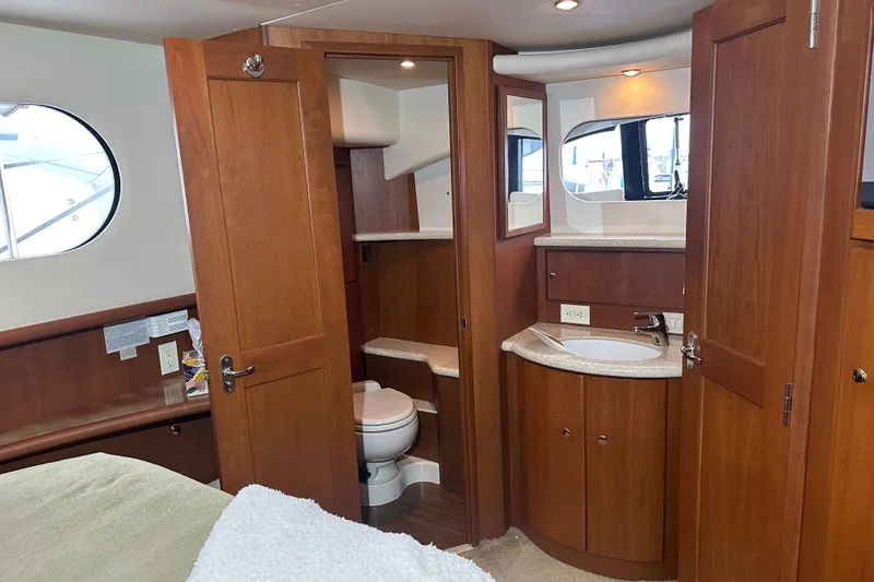 Slide: The Image of Interior of 2005 Silverton 43 Motor Yacht featuring wooden cabinetry and compact bathroom. - 26