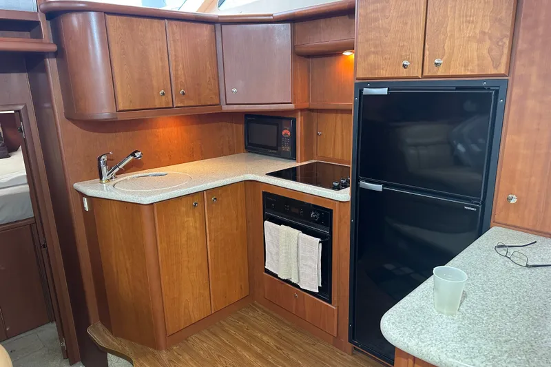 Slide: The Image of 2005 Silverton 43 Motor Yacht kitchen with wood cabinetry, countertop, and modern appliances. - 22