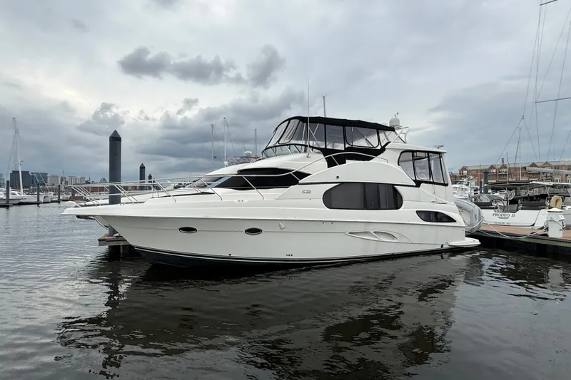Slide: The Image of 2005 Silverton 43 Motor Yacht docked at a marina under cloudy skies. - 9