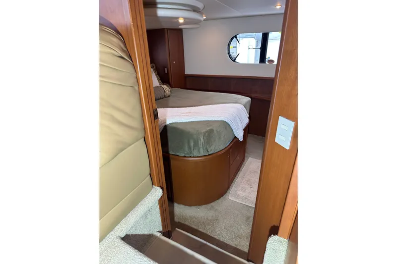 Slide: The Image of Interior of 2005 Silverton 43 Motor Yacht bedroom with cozy bed and porthole window. - 24