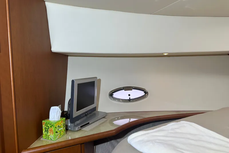 Slide: The Image of 2005 Silverton 43 Motor Yacht interior with TV, porthole, and tissue box on a wooden shelf. - 34