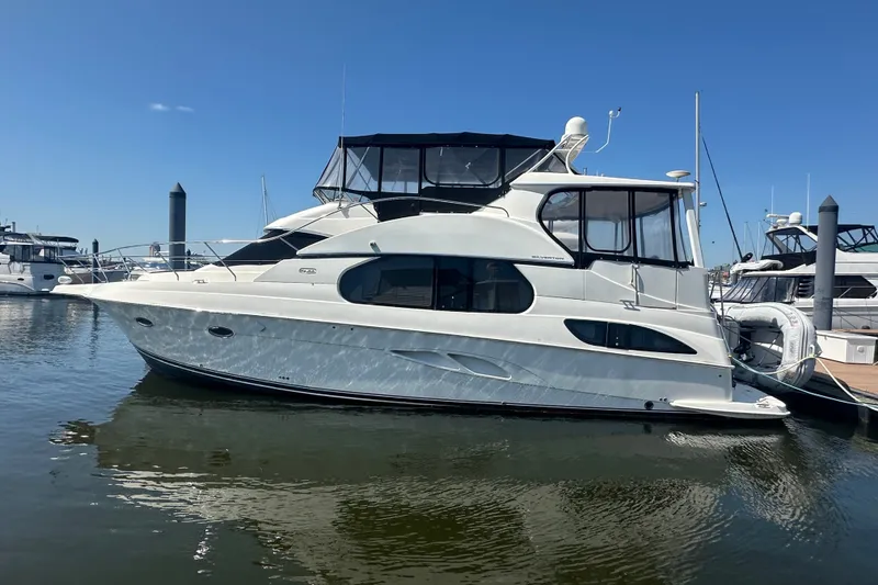 Slide: The Image of 2005 Silverton 43 Motor Yacht docked in a marina under clear blue skies. - 10