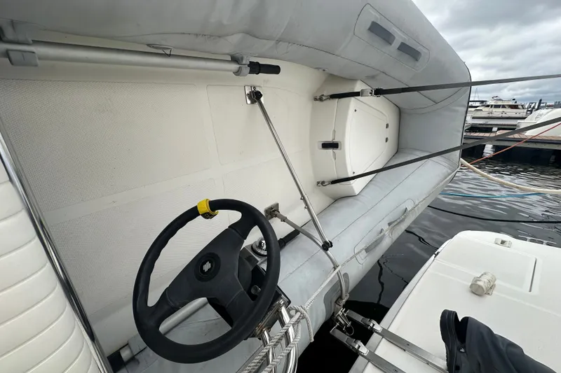 Slide: The Image of 2005 Silverton 43 Motor Yacht with inflatable dinghy and steering wheel, docked at marina. - 48