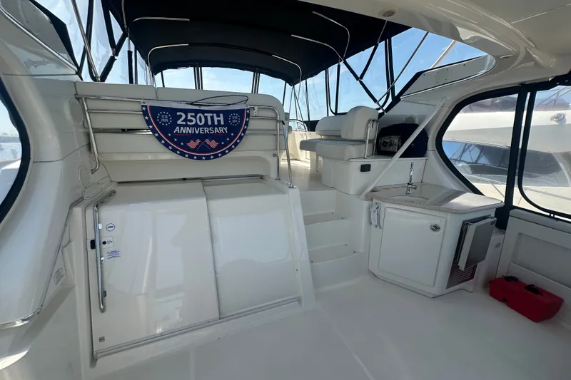 Slide: The Image of 2005 Silverton 43 Motor Yacht interior with 250th anniversary banner, featuring seating and kitchenette. - 17
