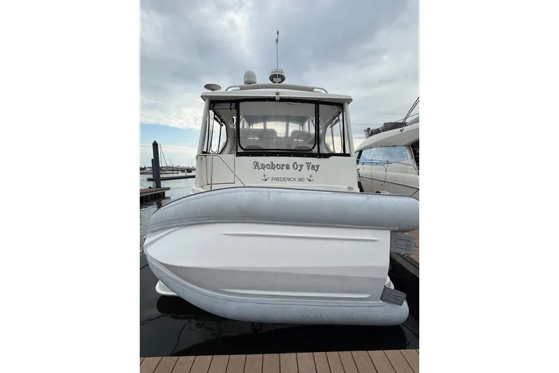 Slide: The Image of 2005 Silverton 43 Motor Yacht docked with inflatable boat, cloudy sky background. - 5
