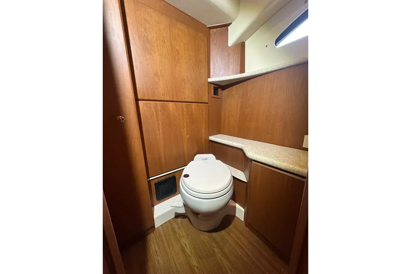 Slide: The Image of 2005 Silverton 43 Motor Yacht bathroom with wooden cabinetry and modern toilet. - 28