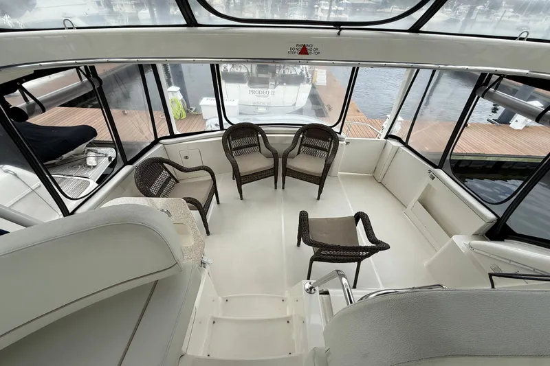 Slide: The Image of 2005 Silverton 43 Motor Yacht interior with wicker chairs and panoramic windows. - 22