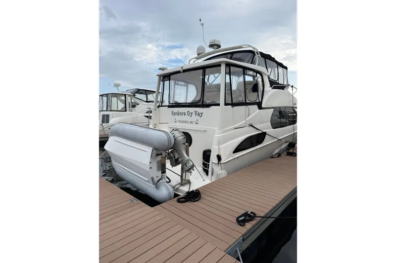 Slide: The Image of 2005 Silverton 43 Motor Yacht docked with inflatable boat attached. - 16