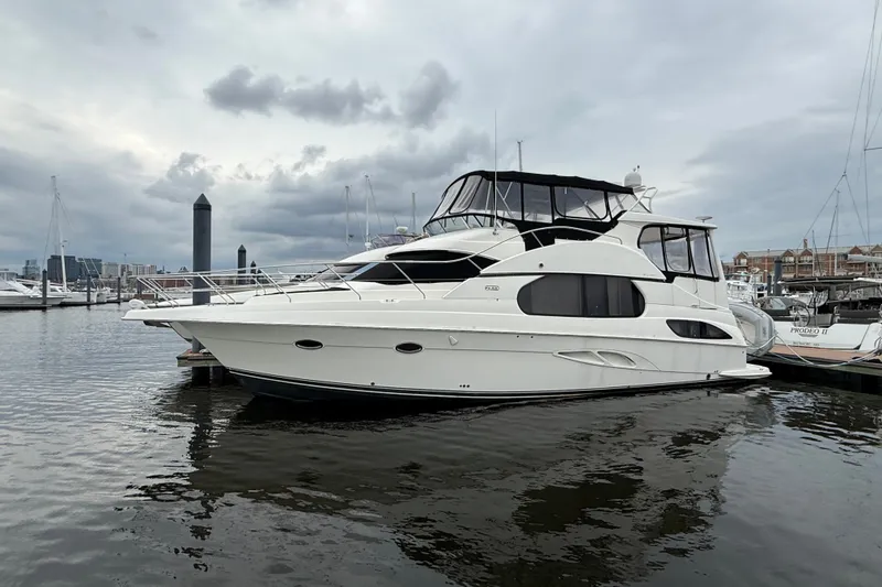 Slide: The Image of 2005 Silverton 43 Motor Yacht docked in a marina under cloudy skies. - 8