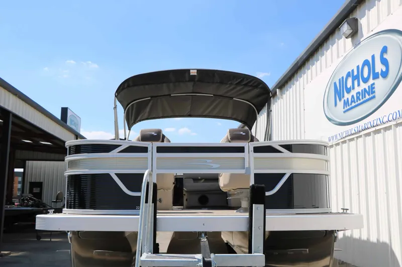 Slide: The Image of A 2027 Bennington 22 SF Tri Toon on a trailer in front of a building with a Nichols Marine sign. - 7