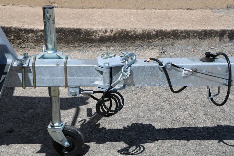 Slide: The Image of Close-up of a boat trailer with a support wheel and hitch on asphalt. - 26