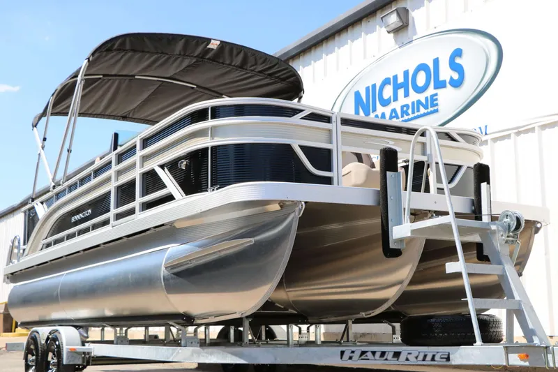 Slide: The Image of A 2027 Bennington 22 SF Tri Toon on a trailer in front of a building. - 6