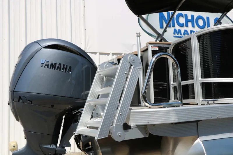 Slide: The Image of A 2027 Bennington 22 SF Tri Toon with a Yamaha outboard motor and swim ladder. - 21