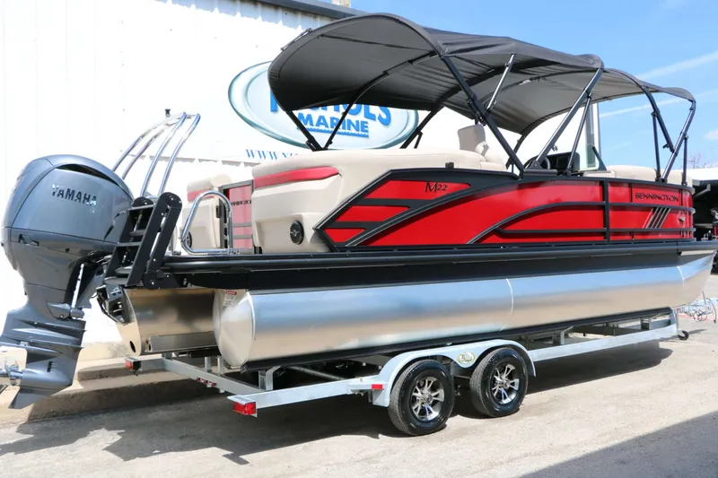 Slide: The Image of A red 2027 Bennington 22 MFB Tri Toon on a trailer, featuring a black canopy. - 14