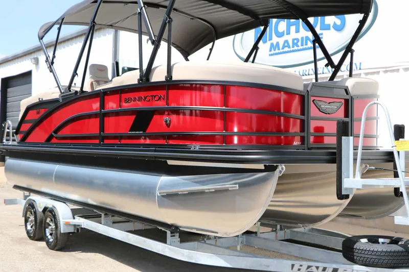 Slide: The Image of A red 2027 Bennington 22 MFB Tri Toon on a trailer, featuring a black canopy. - 7
