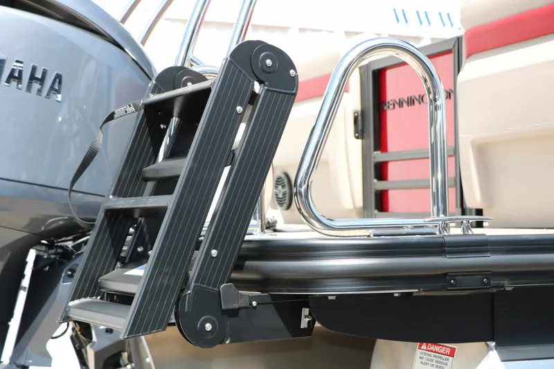 Slide: The Image of A swim ladder on a Bennington 22 MFB Tri Toon boat, next to a Yamaha engine. - 22