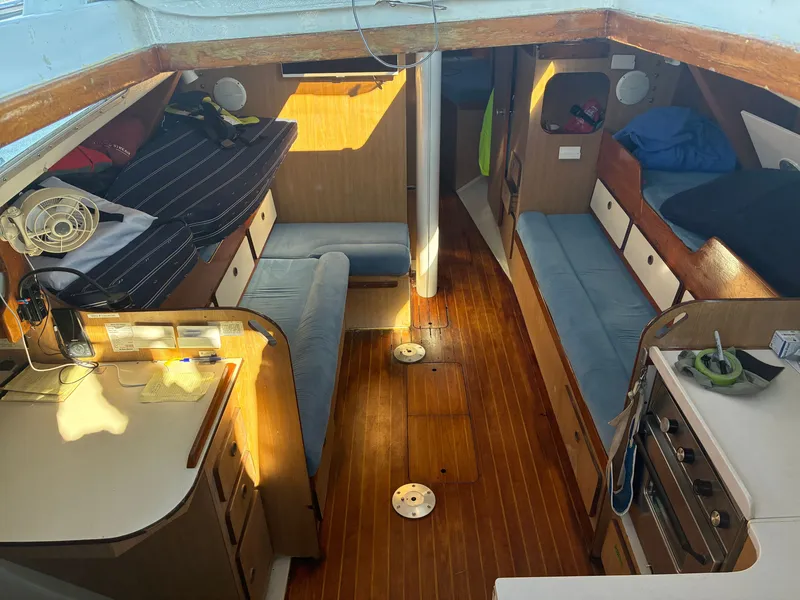 Slide: The Image of Interior of a 1973 Pearson 36 sailboat with wooden flooring and blue cushions. - 27