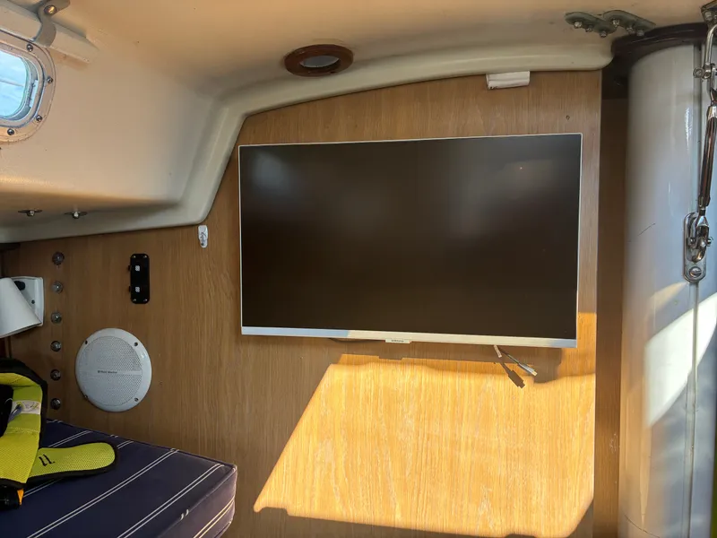 Slide: The Image of The interior of a 1973 Pearson 36 features a modern flat-screen TV mounted on a wooden wall. - 29