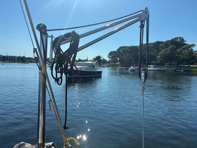Slide: The Image of A sailboat on calm water with another boat in the background, surrounded by trees. - 19