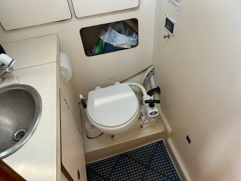 Slide: The Image of The image shows a boat bathroom with a toilet, sink, and storage space. - 37