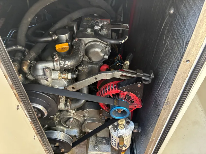 Slide: The Image of An engine compartment with a well-maintained engine, belts, and hoses in a 1973 Pearson 36. - 41