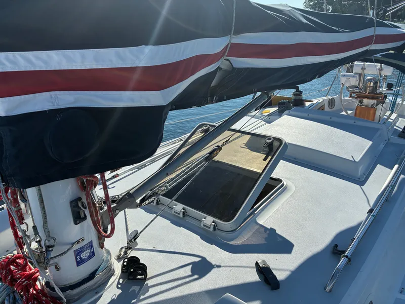 Slide: The Image of A 1973 Pearson 36 sailboat with an open deck hatch and striped sail cover. - 14