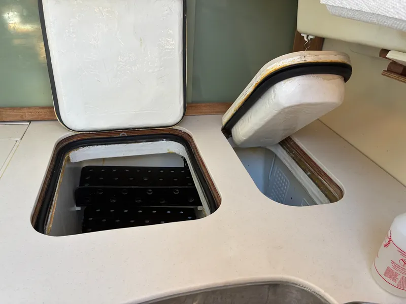 Slide: The Image of The 1973 Pearson 36 features open storage compartments in the galley with white covers. - 33