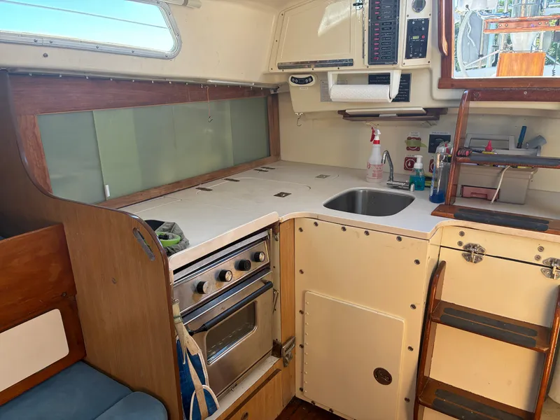 Slide: The Image of The galley of a 1973 Pearson 36 with a stove, sink, and storage space. - 32