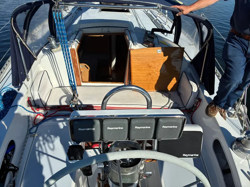 Slide: The Image of The cockpit of a 1973 Pearson 36 with a steering wheel and navigation equipment. - 23
