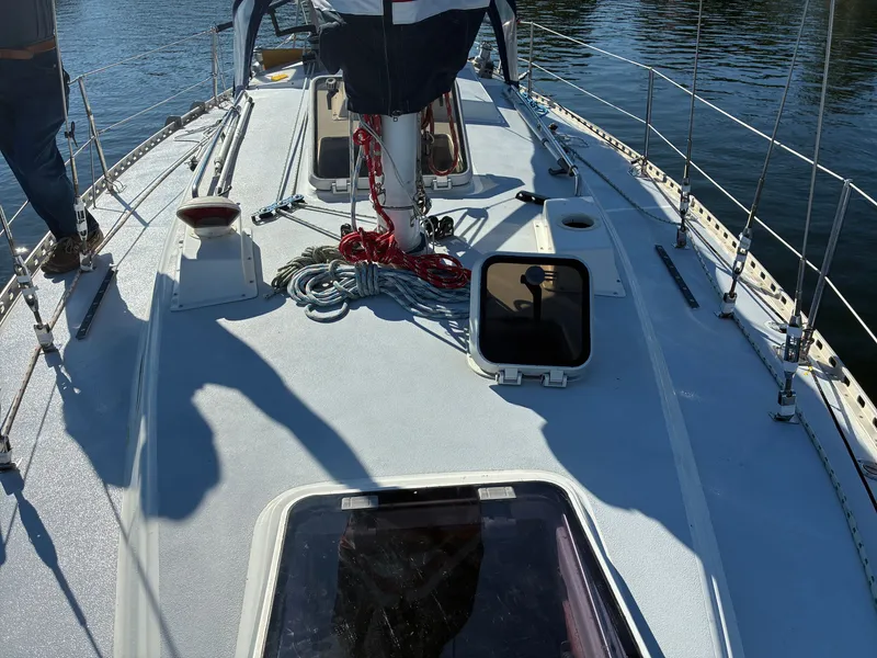 Slide: The Image of The deck of a 1973 Pearson 36 with ropes and hatches, resting on calm water. - 13