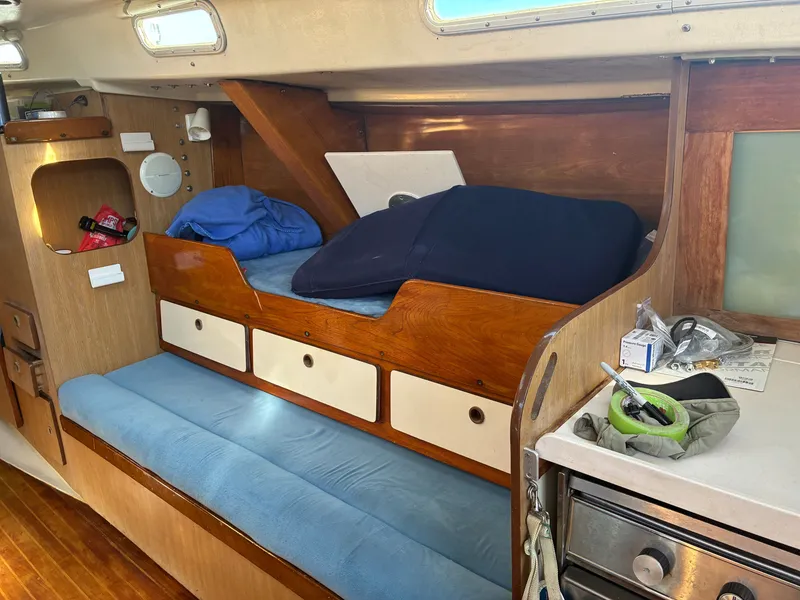 Slide: The Image of Interior of a 1973 Pearson 36 with wooden furnishings and blue cushions. - 30