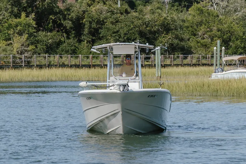 Slide: The Image of 2019 Bulls Bay 230 Center Console boat cruising on a calm waterway with lush greenery. - 6