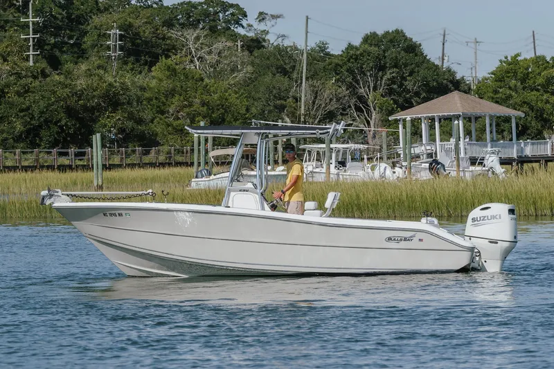Slide: The Image of 2019 Bulls Bay 230 Center Console boat on calm water near a dock. - 4