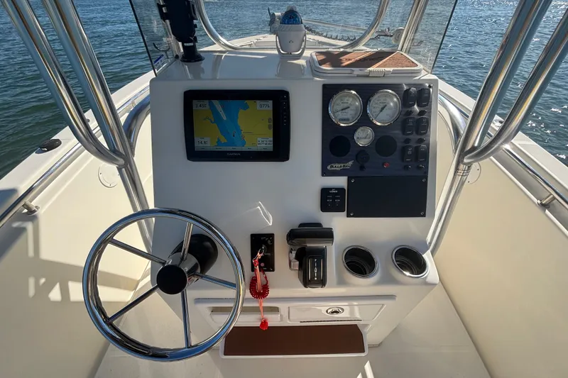 Slide: The Image of 2019 Bulls Bay 230 Center Console boat dashboard with steering wheel and navigation display. - 13