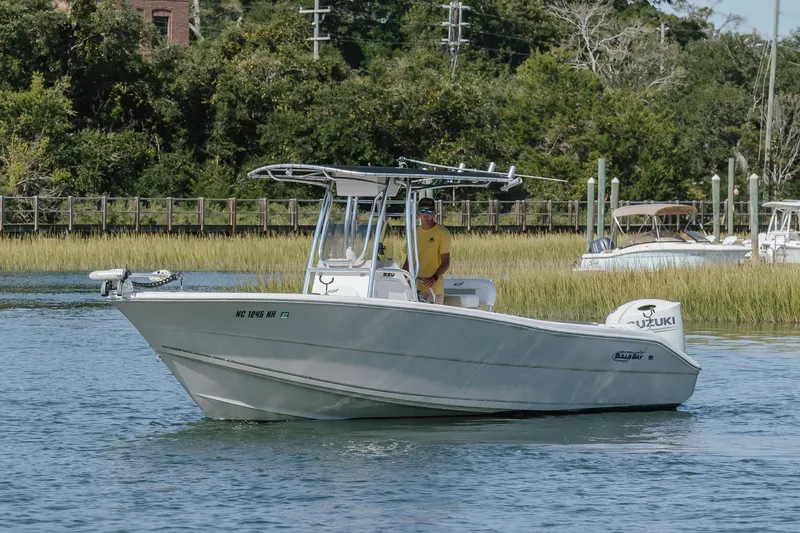 Slide: The Image of 2019 Bulls Bay 230 Center Console boat on water with lush greenery background. - 5